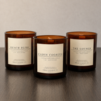 KMAS Signature Candle Bundle featuring The Lounge, Cabin Cookies and Beach Bliss hand-poured coconut wax candles with wooden wicks.